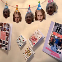 Custom 90th birthday face bunting featuring alternating present-day and childhood throwback photos wearing mini party hats, displayed on a wall above birthday cards.