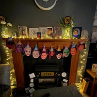 Personalised 30th birthday face bunting showing photo cut-outs of the birthday person through the years, wearing party hats and hanging on a fireplace.